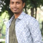 Smiling young man in a casual shirt posing under trees in Rangpur, Bangladesh.